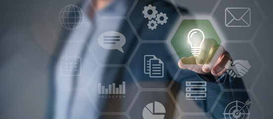 Standing businessman touch a bulb lamp. .Develop business bright idea innovation inspiration concept