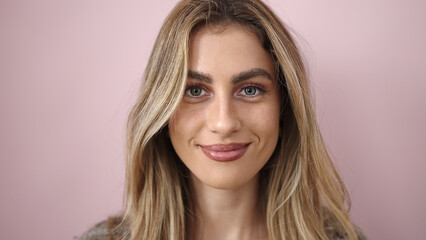 Young blonde woman smiling confident standing over isolated pink background