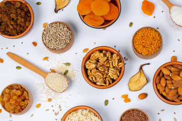 Healthy vegetarian food concept. Assortment of dried fruits, nuts and seeds on white background. Top view. Mixed nuts set closeup.