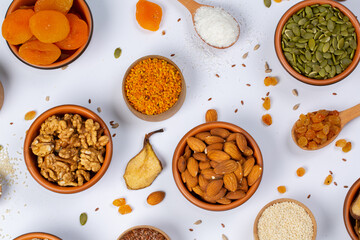 Healthy vegetarian food concept. Assortment of dried fruits, nuts and seeds on white background. Top view.