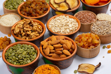 Healthy vegetarian food concept. Assortment of dried fruits, nuts and seeds on white background. Top view. Mixed nuts set closeup.