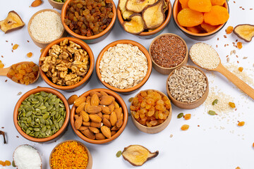 Healthy vegetarian food concept. Assortment of dried fruits, nuts and seeds on white background. Top view.