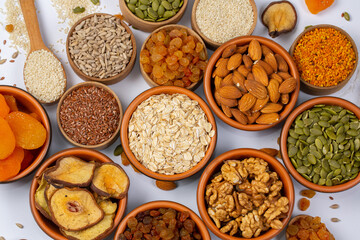 Healthy vegetarian food concept. Assortment of dried fruits, nuts and seeds on white background. Top view.