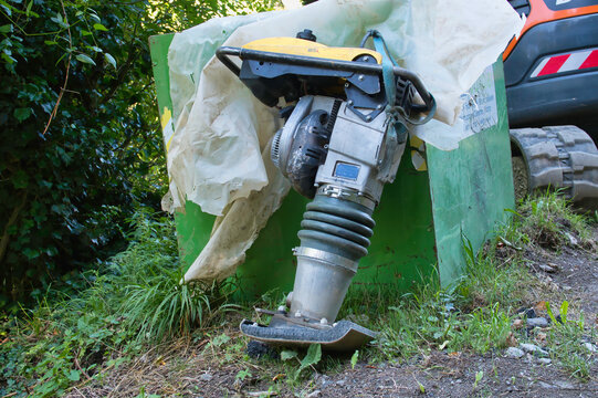 Ein Vibrationsstampfer am Rand eines Waldwegs im closeup