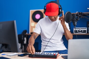 Young latin man musician having dj session at music studio