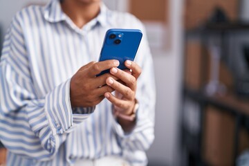 Young beautiful hispanic woman business worker using smartphone at office