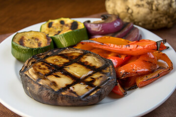 A grilled portobello mushroom cap with a side of roasted vegetables