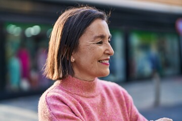 Middle age woman smiling confident standing at street