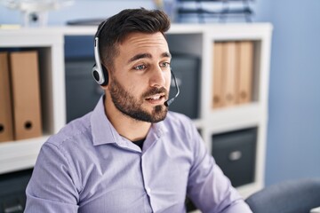 Young hispanic man call center agent working at office
