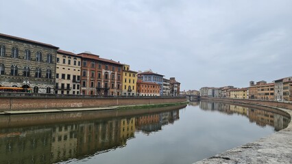 Fototapeta na wymiar Pisa, Italy - February 25, 2023: View of the medieval town of Pisa from bridge 