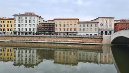 Fototapeta na wymiar Pisa, Italy - February 25, 2023: View of the medieval town of Pisa from bridge 