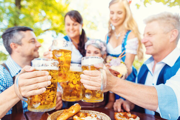 Group of friends toasting in Bavarian beer garden - 585440942