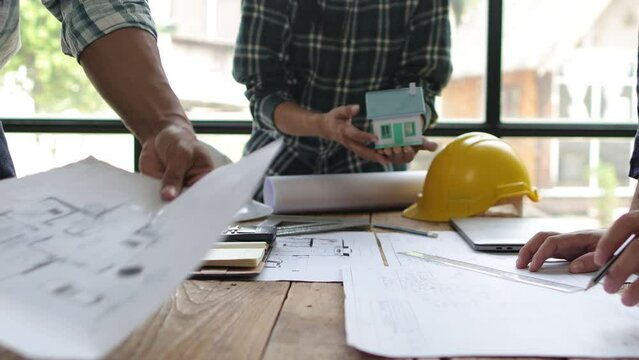 Architect team meeting, Group of architects and contractor engineers meet to discuss the design and layout of the construction project.
