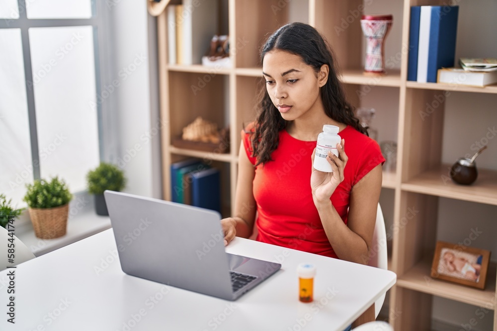 Canvas Prints Young brazilian woman doing video call showing pills to the doctor thinking attitude and sober expression looking self confident