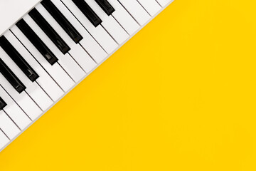 Piano keys on a yellow background, top view, flat lay, copy space.