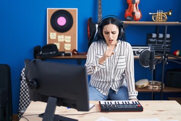 Fototapeta na wymiar Young modern girl with blue hair at music studio wearing headphones feeling unwell and coughing as symptom for cold or bronchitis. health care concept.