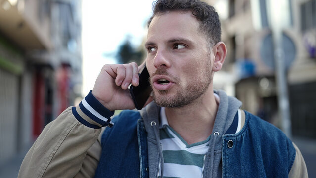 Young caucasian man speaking on the phone at street