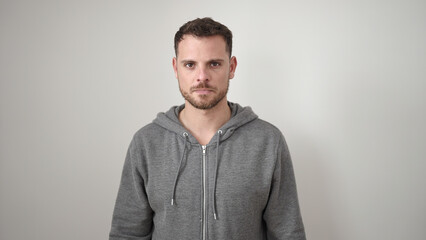 Young caucasian man standing with serious expression wearing sweatshirt over isolated white background