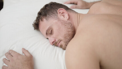 Fototapeta na wymiar Young caucasian man lying on bed sleeping shirtless at bedroom
