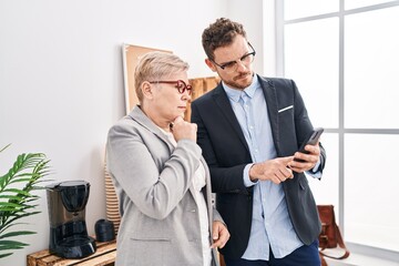 Mother and son business workers using smartphone at office