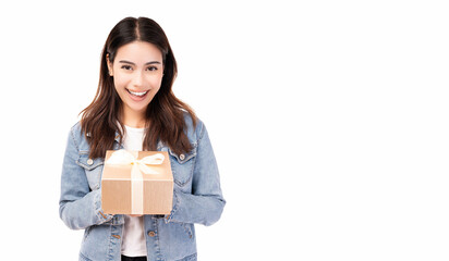 Happy young pretty woman holding gift box Smiling brunette woman in denim jacket holding birthday...