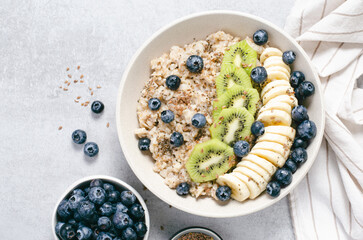 Oatmeal Bowl with Blueberry, Banana and Kiwi, Oat Porridge in a Bowl on Bright Background, Healthy Snack or Breakfast
