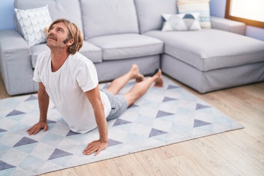 Young blond man stretching back at home