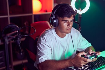 Young hispanic man streamer playing video game using joystick at gaming room © Krakenimages.com