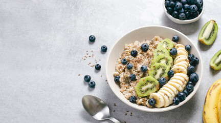 Oatmeal Bowl with Blueberry, Banana and Kiwi, Oat Porridge in a Bowl on Bright Background, Healthy...