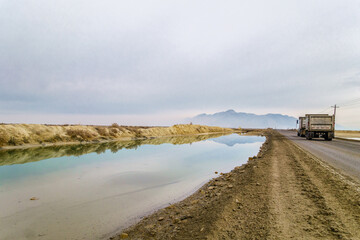 Truck driving along canal in the Great Salt Lake, Utah, US