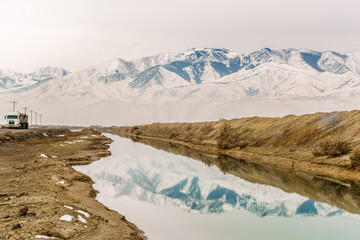 Truck driving along canal in the Great Salt Lake, Utah, US