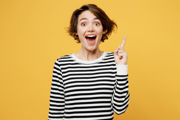 Young insighted smart proactive woman wear casual striped black and white shirt holding index finger up with great new idea isolated on plain yellow color background studio portrait Lifestyle concept © ViDi Studio