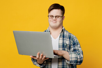 Young confident smiling IT man with down syndrome wear glasses casual clothes hold use work on...