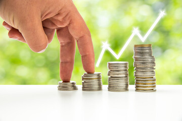 Close up of hand stacking gold coins with green bokeh background ,Business Finance and Money concept,Save money for prepare in the future.