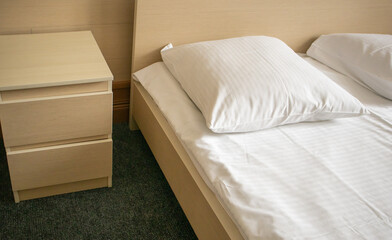 Close-up of the bed and bedside table, modern and bright interior of the bedroom in the hotel