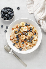 Oatmeal Bowl, Oat Porridge with Blueberry, Banana and Pecans in a Bowl on Bright Background, Healthy Snack or Breakfast