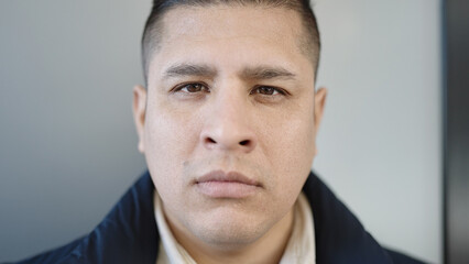 Obraz premium Young hispanic man standing with serious expression over isolated white background