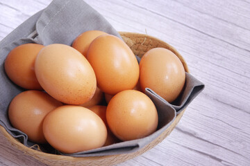 Basket of eggs on a wooden table.