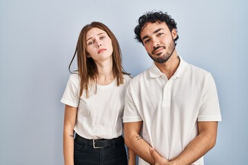 Fototapeta premium Young couple wearing casual clothes standing together looking sleepy and tired, exhausted for fatigue and hangover, lazy eyes in the morning.