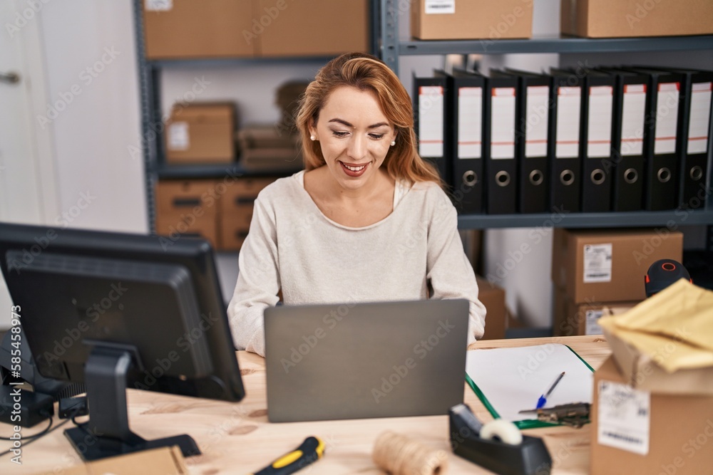 Wall mural Young woman ecommerce busines worker using laptop working at office