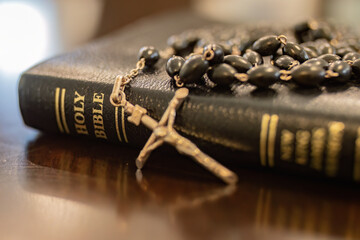 Catholic rosary and crucifix laying on leather bound holy Bible close up, Christian, Christianity, faith and grace of Jesus Christ