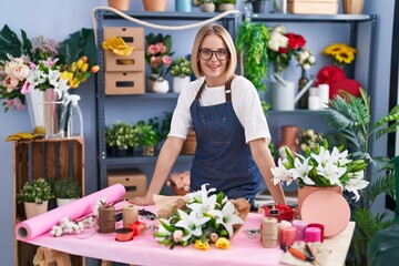 Young blonde woman florist smiling confident standing at florist shop