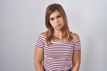Young hispanic woman standing over isolated background depressed and worry for distress, crying...