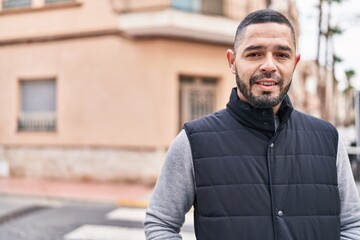 Naklejka premium Young latin man smiling confident standing at street