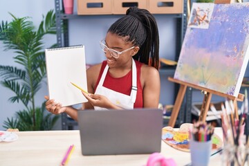 African american woman artist having online draw lesson at art studio
