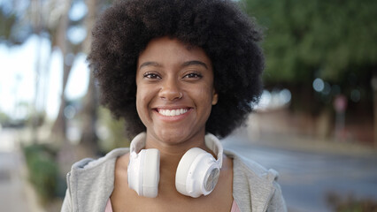 African american woman smiling confident wearing headphones at street © Krakenimages.com