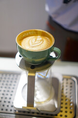 A mint mug set of coffee, a cup of coffee, nicely pour rosetta latte art coffee on a coffee pour over cup