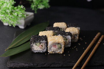 Sushi rolls on black background with salmon cheese and fish