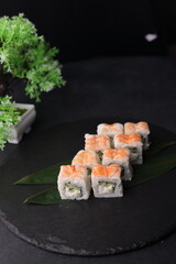 Sushi rolls on black background with salmon cheese and fish