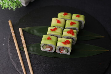 Sushi rolls on black background with salmon cheese and fish